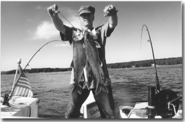 The author holding a string of Lakers while trolling between the two oldest hand crank downriggers on Lake Winni.