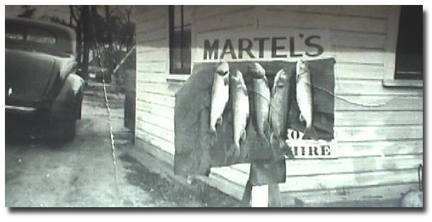 Five large trout in front of Martel's - a sign of success! circa 1940s