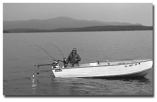 Ted St. Onge trolling with Osippee Mountains in the background. You can see the Dave Davis spinners attached to the downrigger ball on this side of the boat. He uses them as an attractor and has his release device 18" above them on the cable with his sewn shiner spinning slowly just behind the Davis spinners and he always catches salmon and trout with this rig.